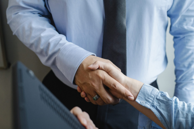 Anonymous colleagues shaking hands before business meeting