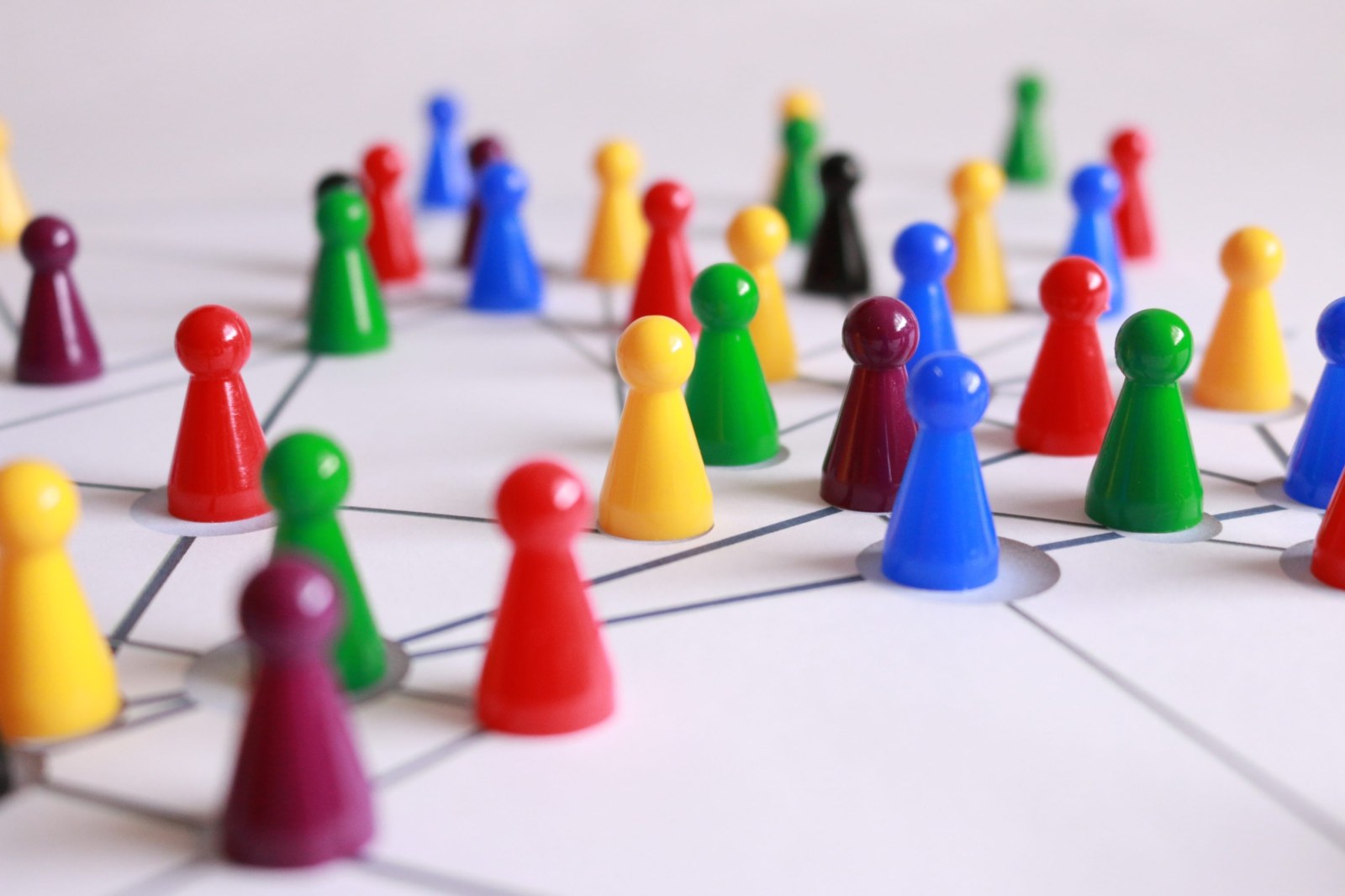Close up photography of yellow green red and brown plastic cones on white lined surface